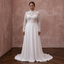 White lace wedding dress with high neckline, long sleeves, and flowing A-line skirt