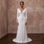 White crepe wedding dress with long sleeves, V-neck, buttoned front, scalloped trim