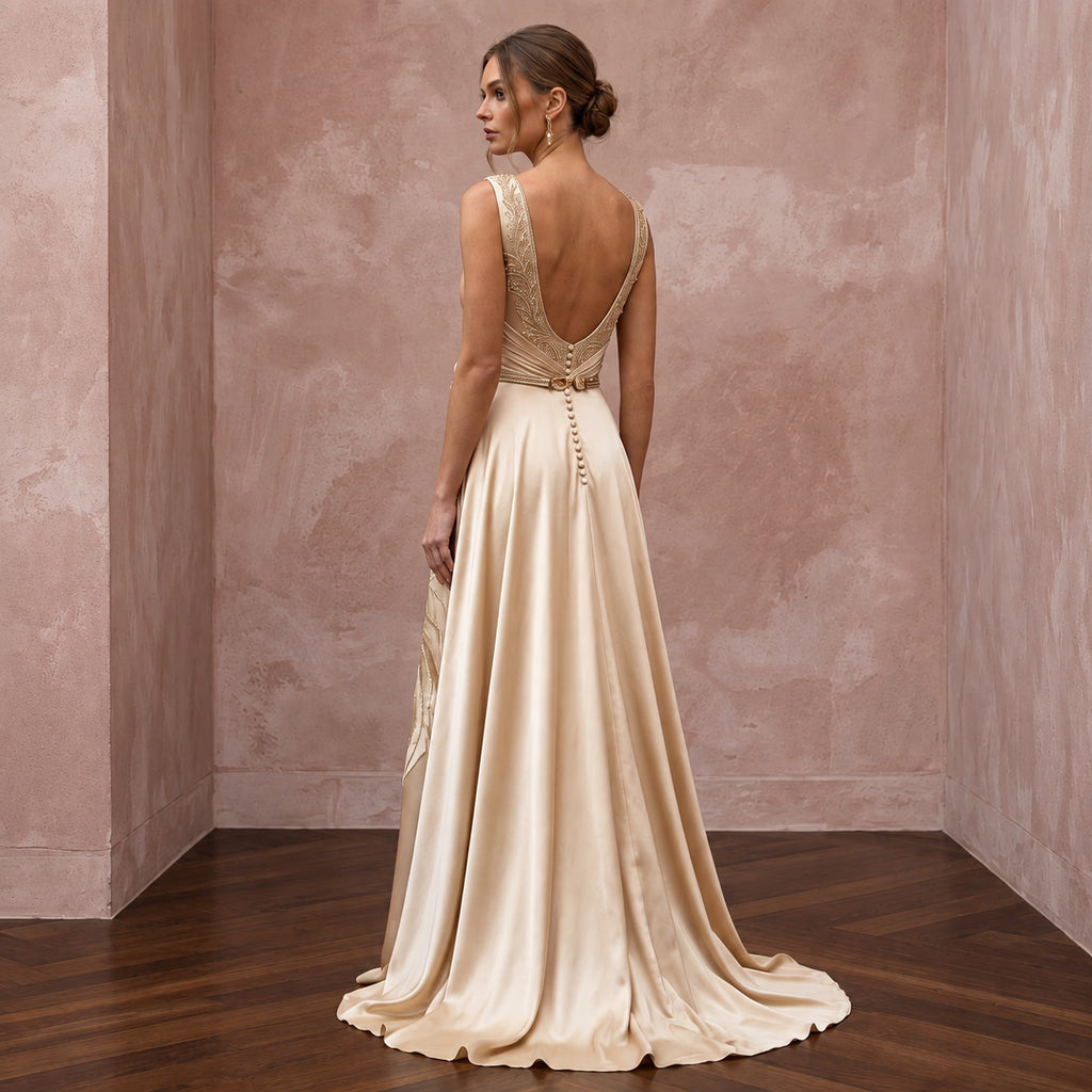 Champagne silk charmeuse maxi dress with plunge neck and flowing skirt, featuring elegant back detail.