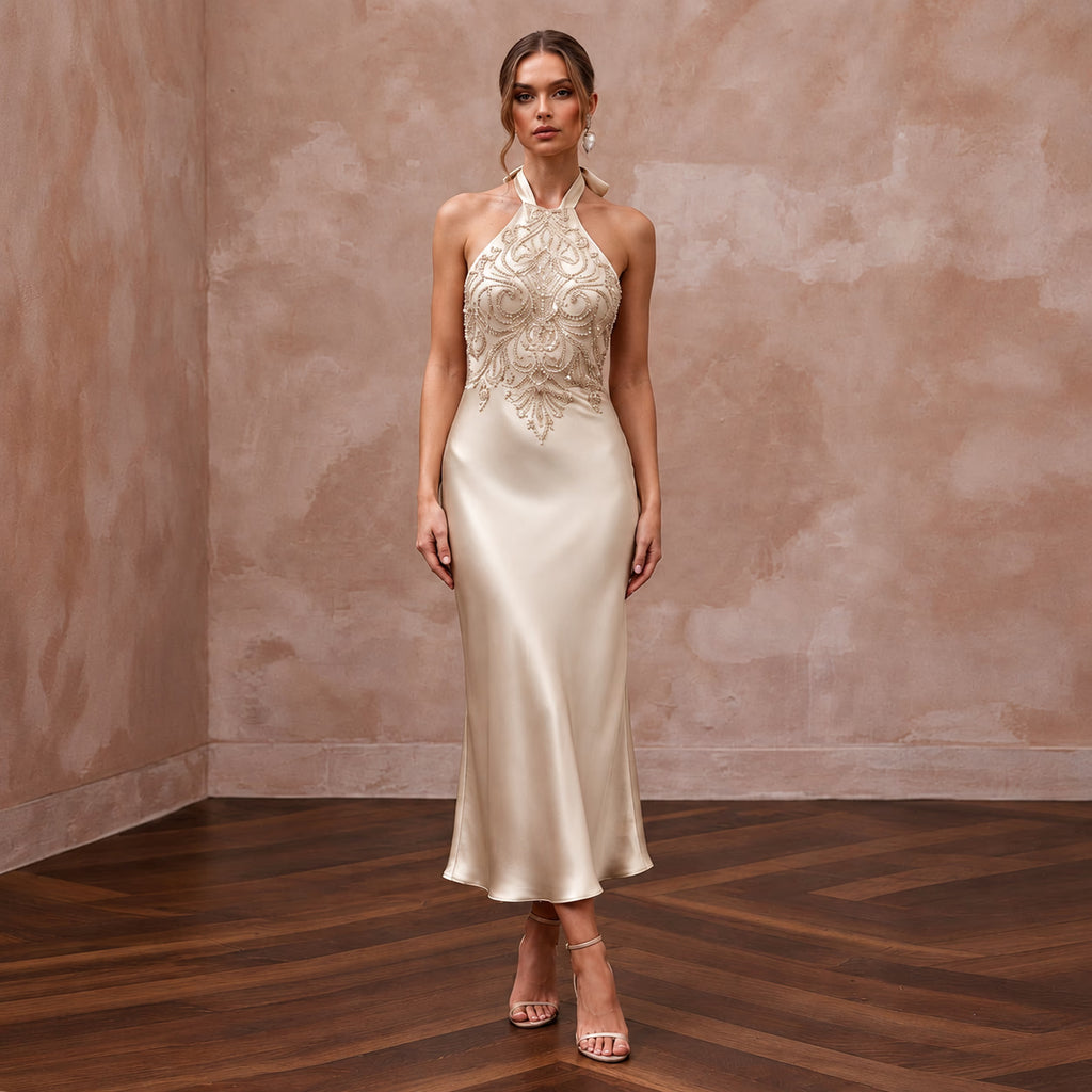 Champagne silk satin halter neck midi slip dress with intricate beaded detailing, perfect for wedding guests.