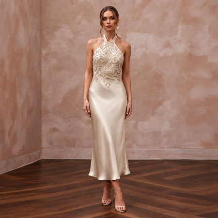 Champagne silk satin halter neck midi slip dress with intricate beaded detailing, perfect for wedding guests.