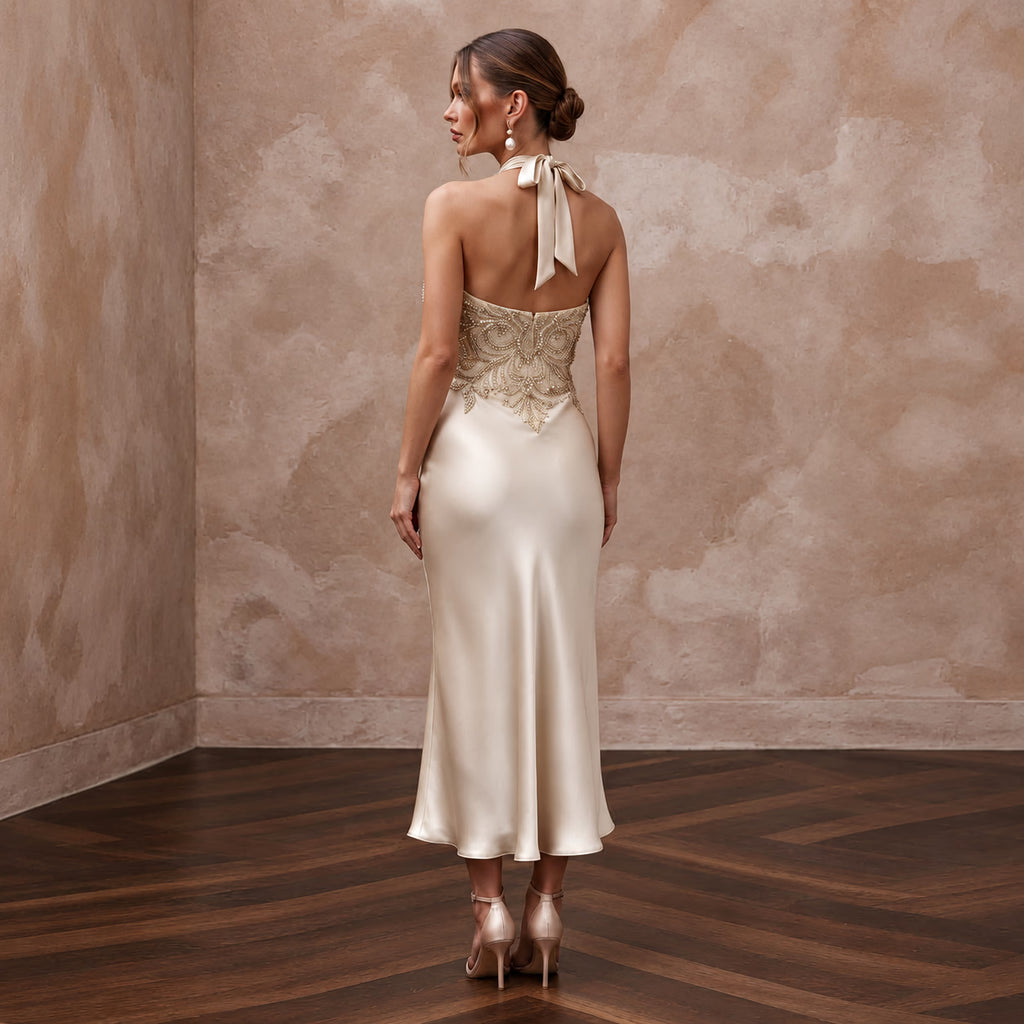 Champagne silk satin halter neck midi slip dress with embellished back, perfect for wedding guests. Elegant and chic.
