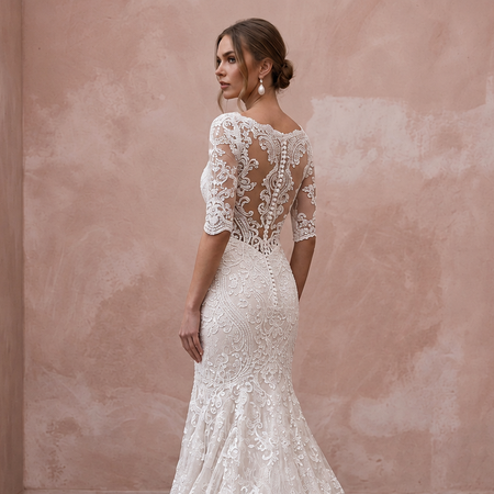 Elegant mermaid lace bridal dress with chapel train, featuring a detailed back and three-quarter sleeves, perfect for a church wedding.