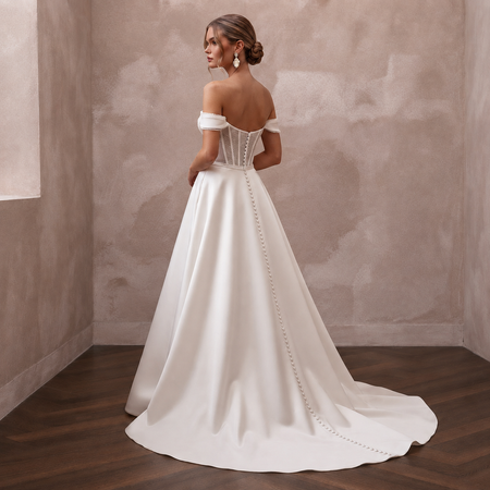 Off-the-shoulder satin wedding gown with corset back and chain-trim detail