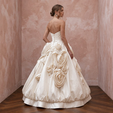 Elegant cream satin strapless wedding gown featuring a bubble skirt and floral organza details. Perfect for bridal style.