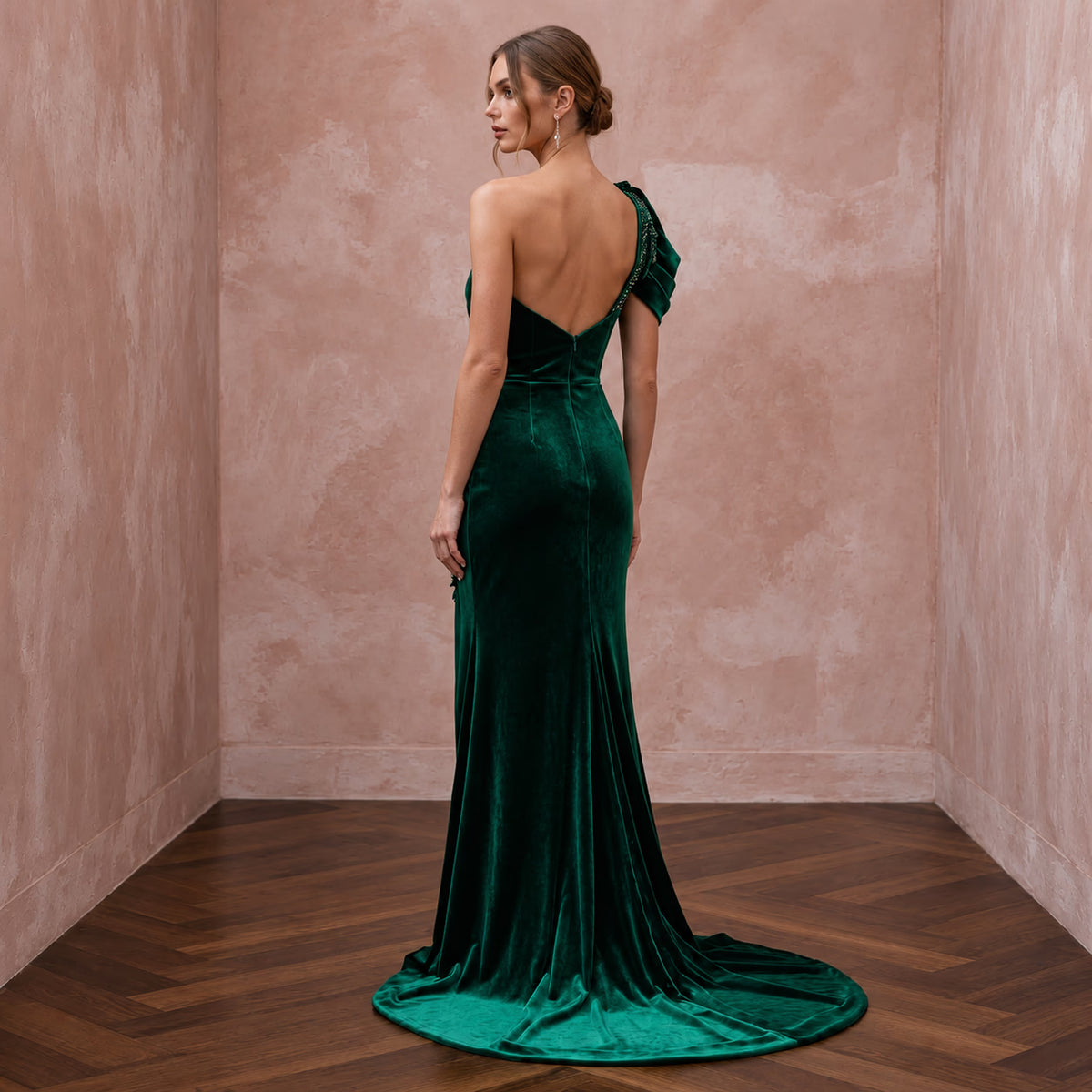 Emerald green velvet asymmetrical one-shoulder formal gown with a sleek silhouette and elegant train.