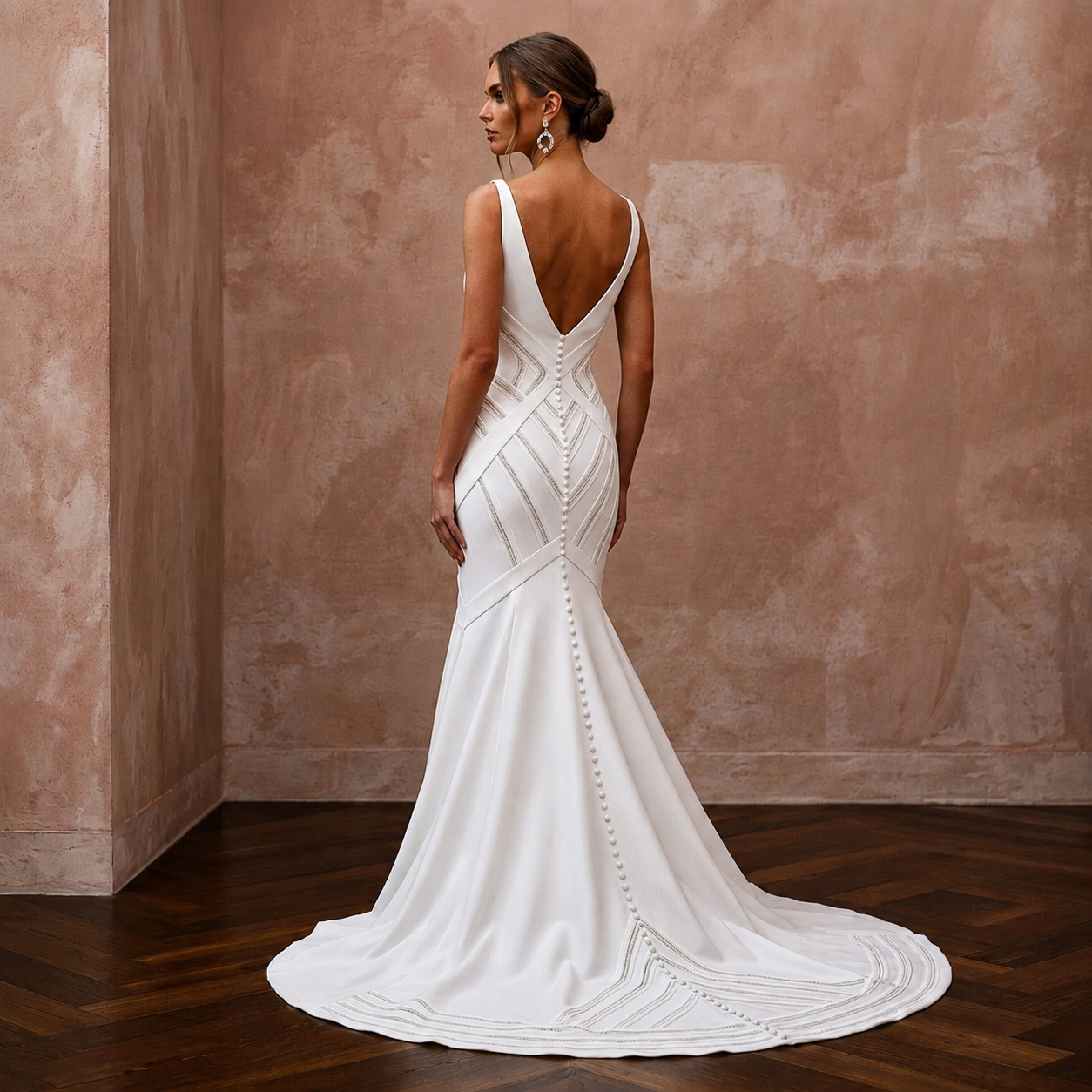 White V-back mermaid wedding dress with geometric panel detailing and draped train