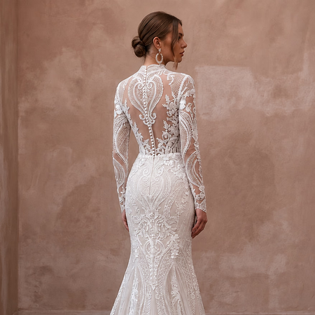 White lace mermaid wedding dress with long sheer sleeves and detailed back panel