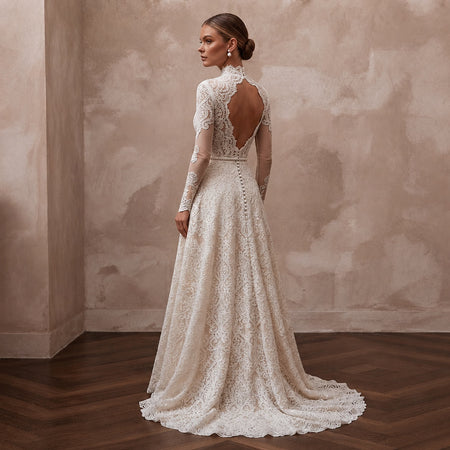 Lace bridal gown with long sleeves, open back lace detail and flowing A-line skirt
