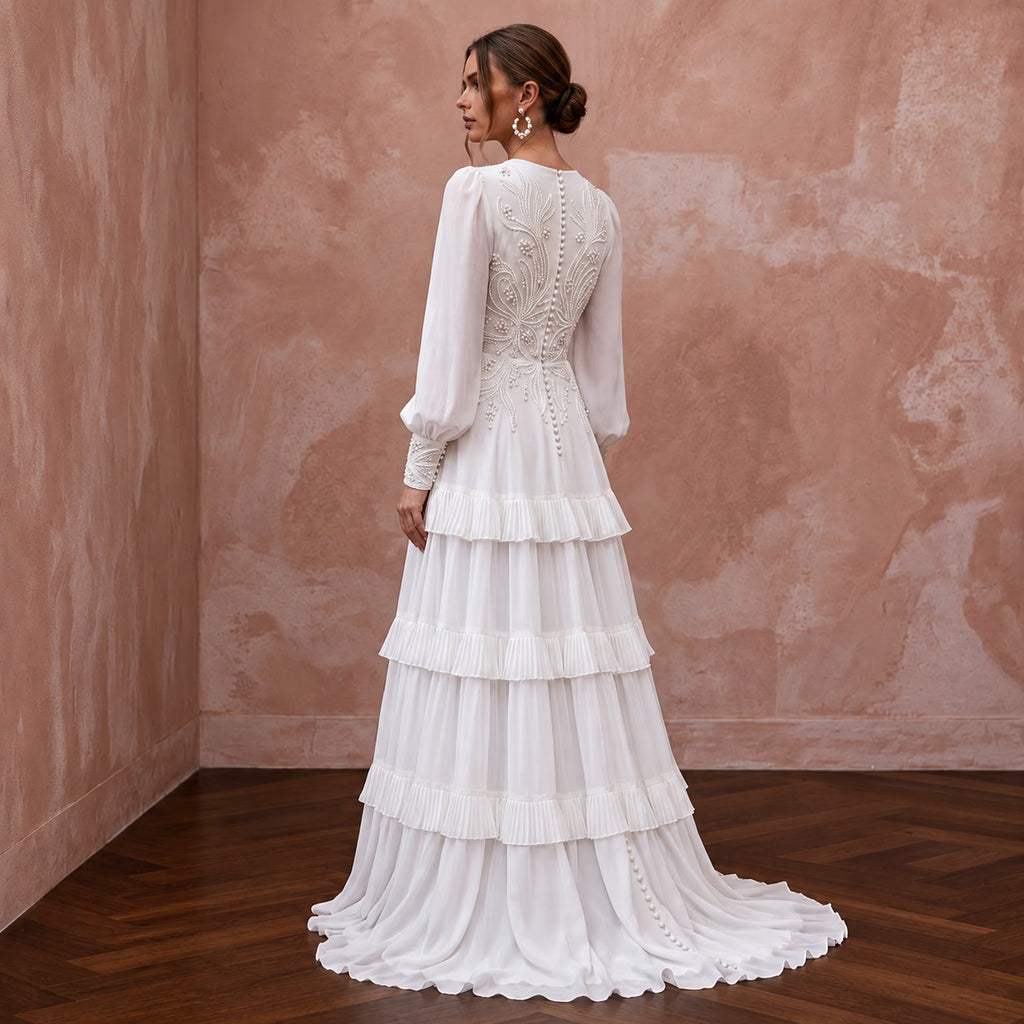 Elegant pure white chiffon gown featuring a tiered skirt and long sleeves, adorned with intricate embroidery.