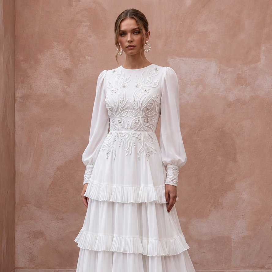 Modest pure white chiffon gown with long sleeves, tiered skirt, and intricate embroidery details. Perfect for special occasions.