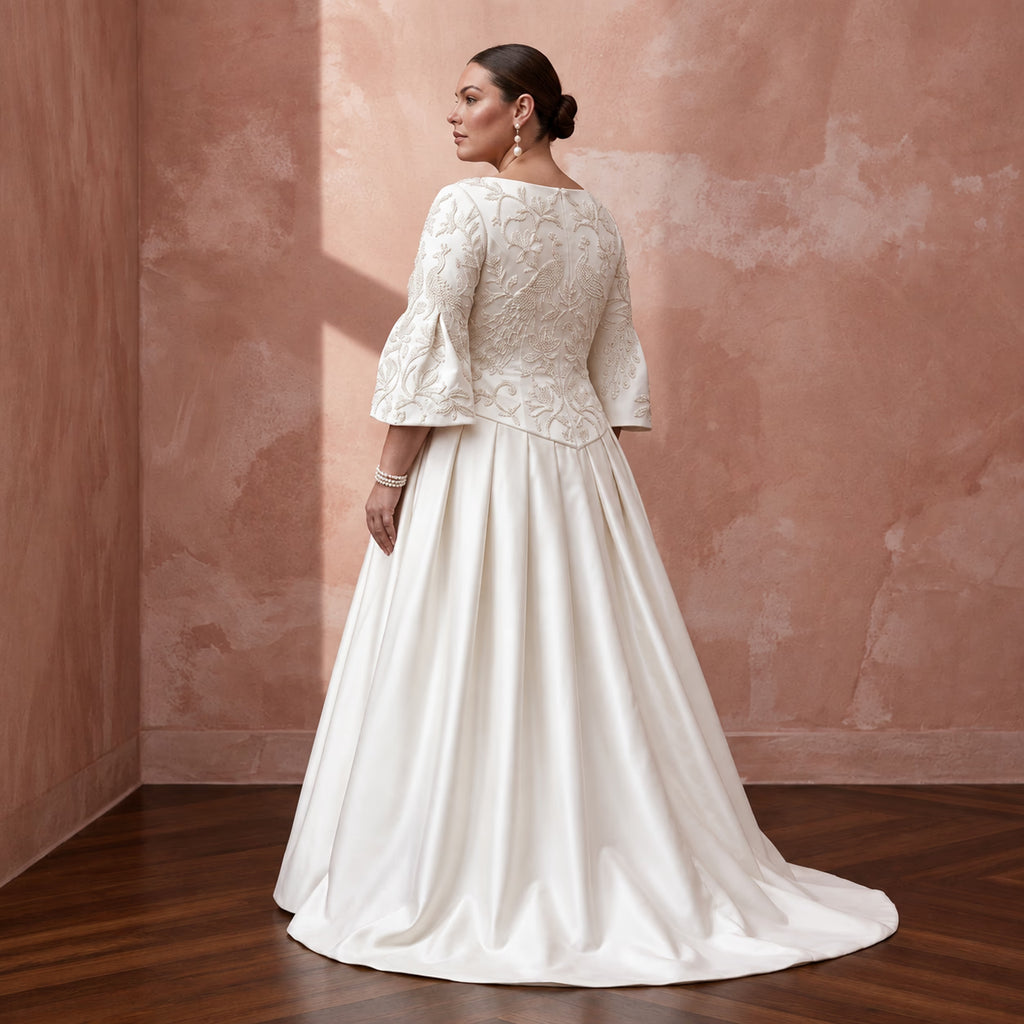Plus size ivory duchess satin dress with embroidered bodice and drop waist, featuring flared sleeves and a full skirt.