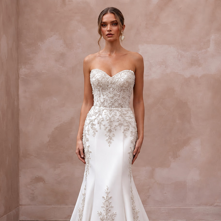 Pure white matte satin dropped waist trumpet wedding dress with intricate bead detailing on the bodice.