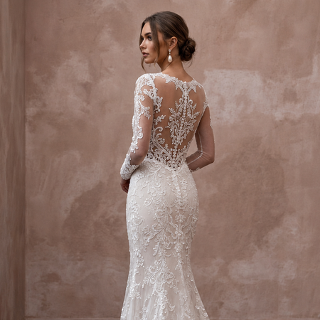 Lace wedding dress with long sleeves, sheer back, and trumpet silhouette