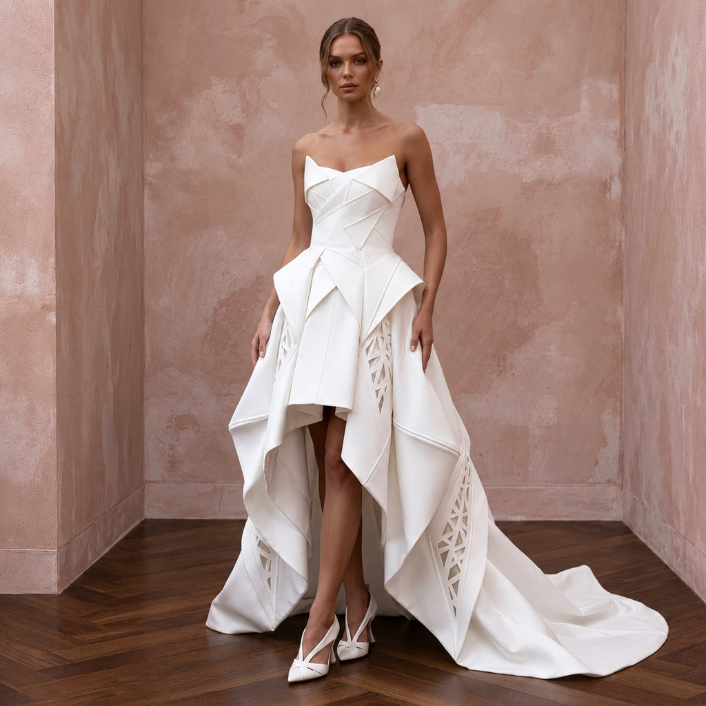 Sculptural white mikado silk architectural dress with a high-low hem, featuring intricate detailing and elegant silhouette.