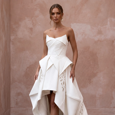 Sculptural white mikado silk architectural dress with high-low hem and intricate detailing. Perfect for formal occasions.