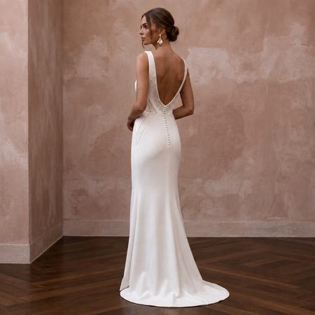 White crepe wedding dress with V-neck, sheath silhouette, lace-trim open back