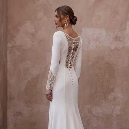 White crepe wedding dress with lace open-back panel, long sleeves, slim fitted skirt