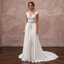 Elegant boho bridal gown with lace cap sleeves, intricate bodice, and sweep train, perfect for a destination wedding.