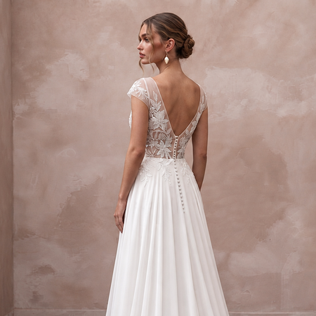 Elegant chiffon bridal dress with embroidered bodice, deep V-back, and sweep train, perfect for a tropical wedding.