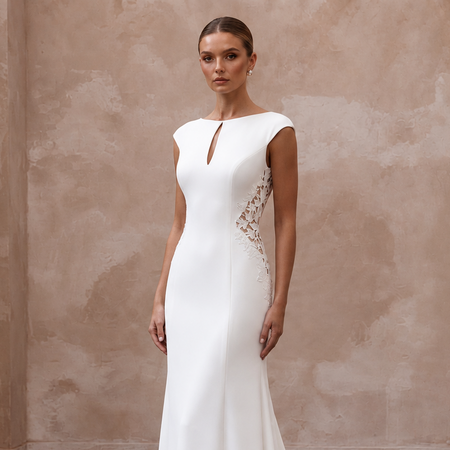 Elegant white crepe bridal gown with lace cutouts and a keyhole neckline, featuring a sweep train for a minimalist wedding.