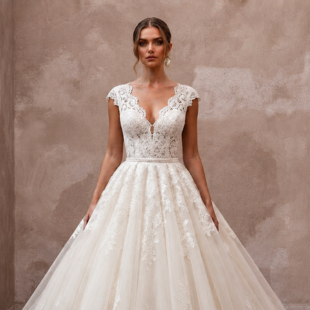 White lace V-neck wedding dress with cap sleeves and full ballgown skirt